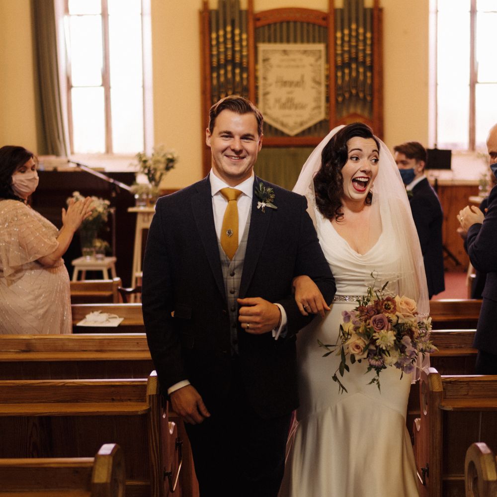 Bride & groom walk down aisle after marriage 