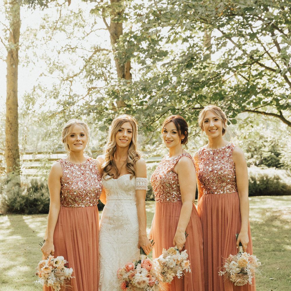 Bride and bridesmaids in coral embellished bridesmaids dresses