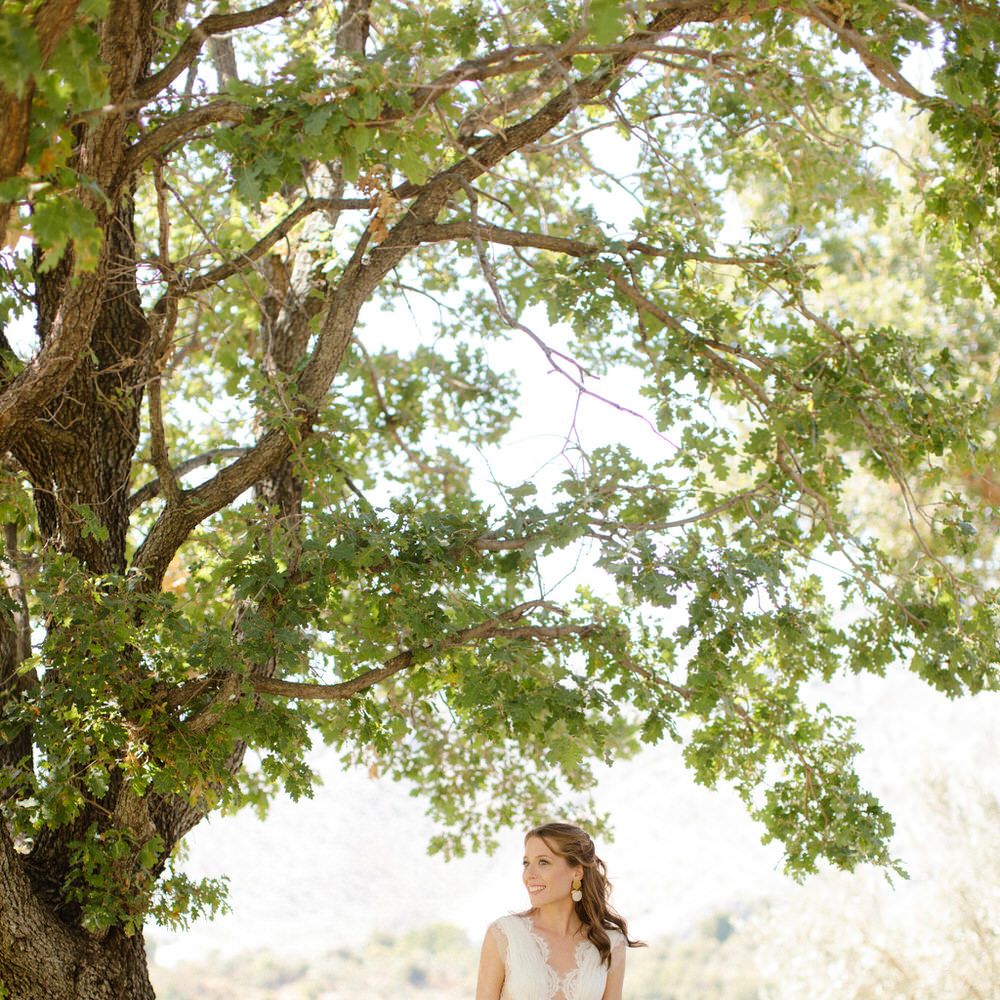 The bride wearing a Vasia Tzotzopoulou wedding dress with a lace top and plunging neckline