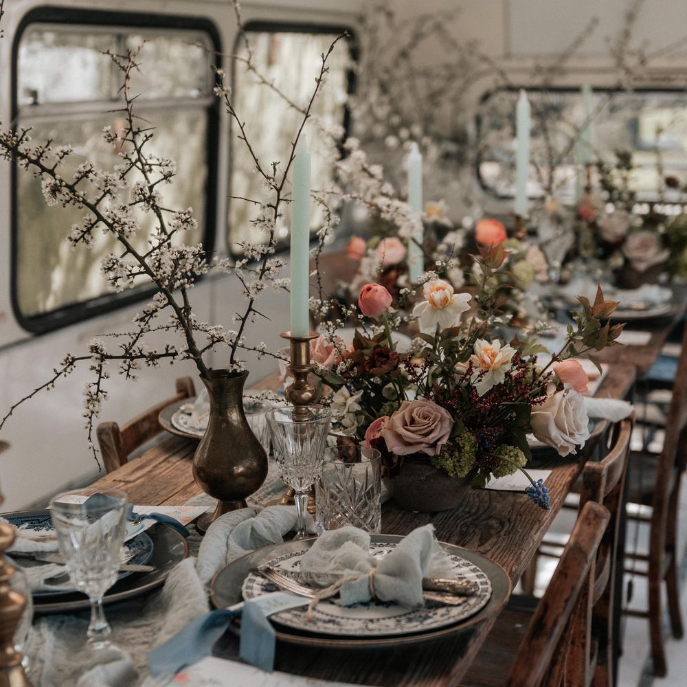 Rustic wooden table with floral decor and pale grey plates