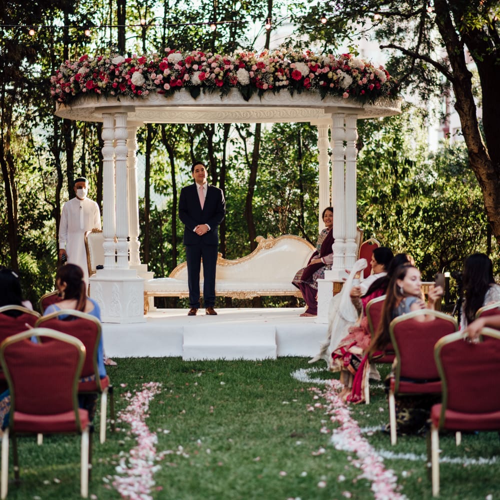 Groom awaits bride at the end of the aisle on their wedding day