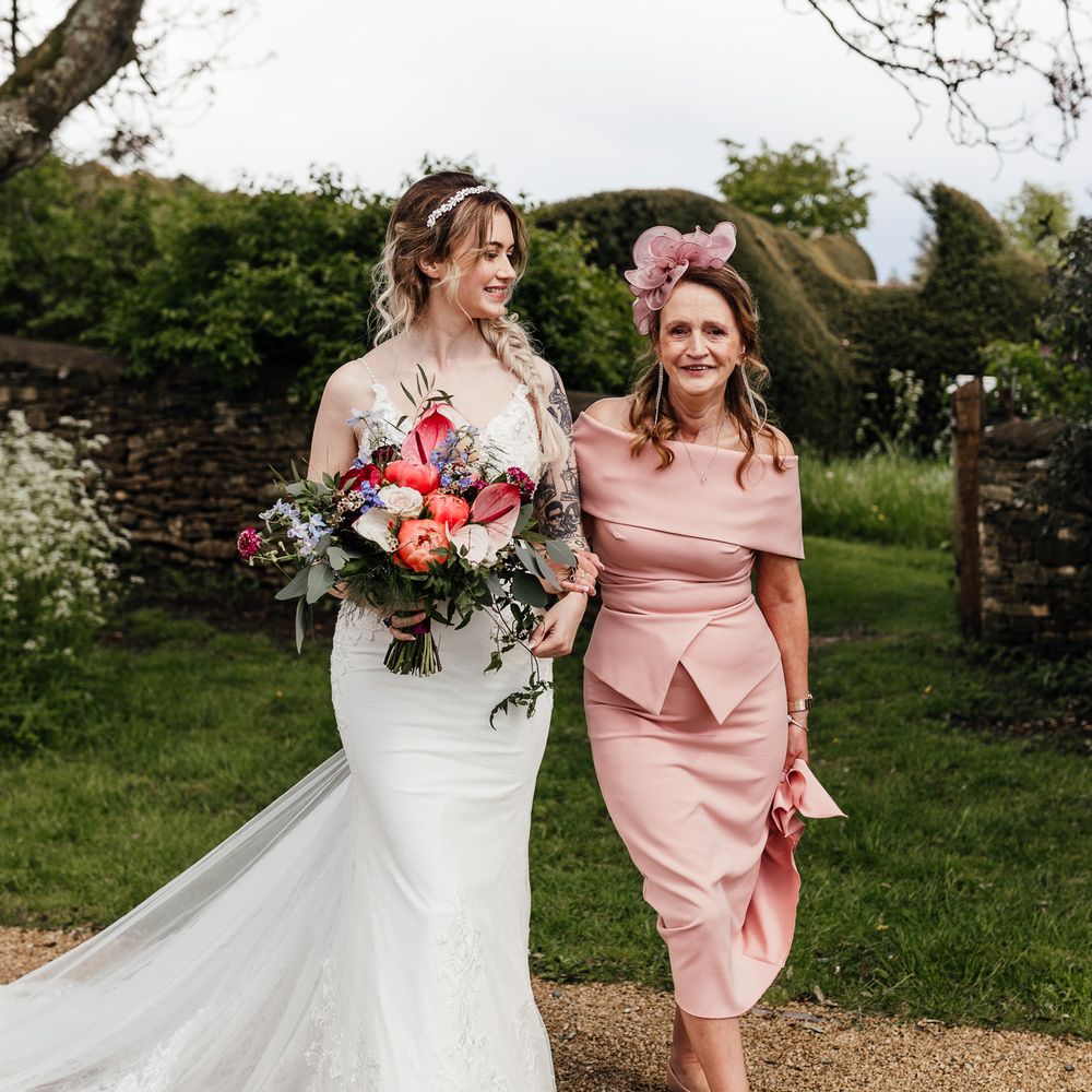 Bride walks with her mother down the aisle