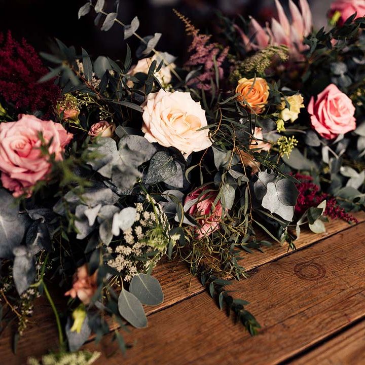peach and pink roses and foliage wedding flower arrangement 
