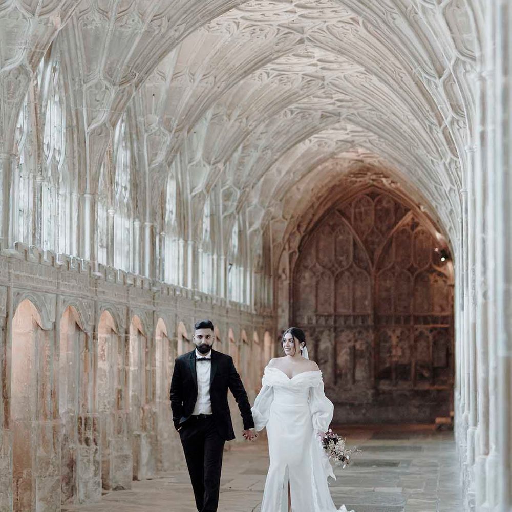 Groom in a tuxedo and bride in an off the shoulder wedding dress with long sleeves at historic wedding venue Blackfriars Priory 
