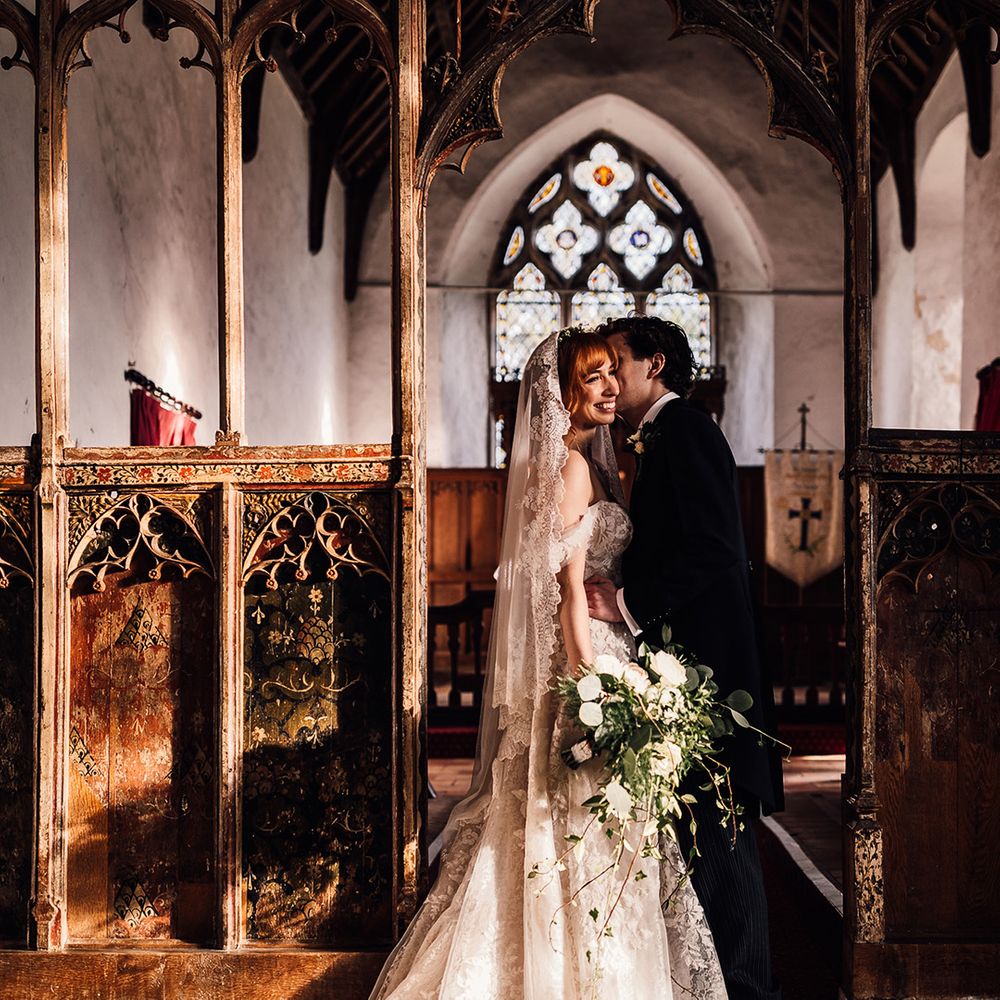 Bride and groom share a moment in the sunlight at church