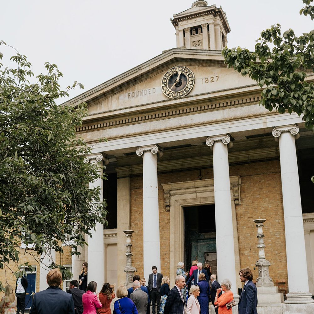 Wedding guests gather outside of the Asylum Chapel wedding venue after the ceremony