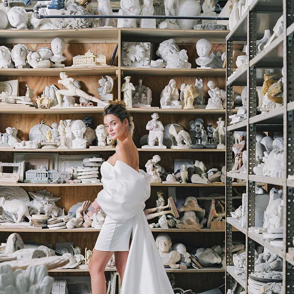 Bride in short wedding dress with off the shoulder bow detail wearing white lace up wedding shoes