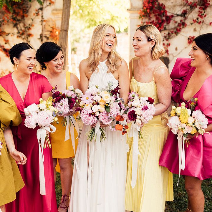 Bridal party shot with the bridesmaids in sunset tones and statement dresses for the destination wedding 