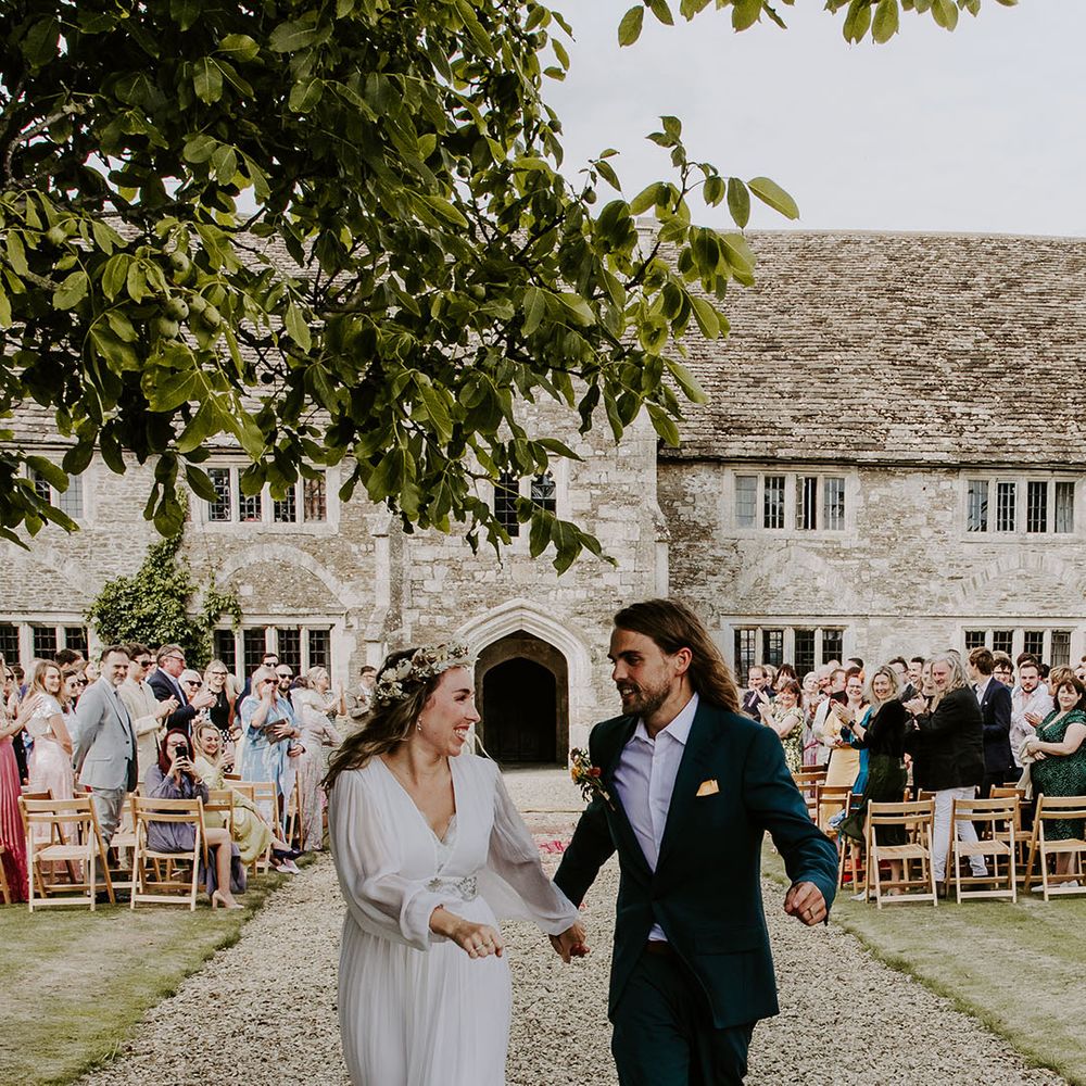 Groom wears green suit complete with pocket square and floral buttonhole 