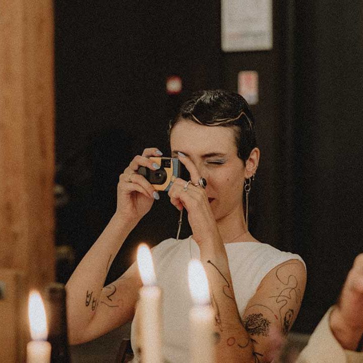 Lisa takes picture on disposable camera during wedding reception 