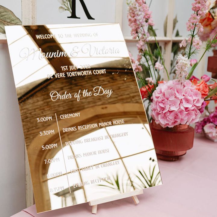 Modern mirror order of the day wedding sign with pink hydrangeas floral arrangement