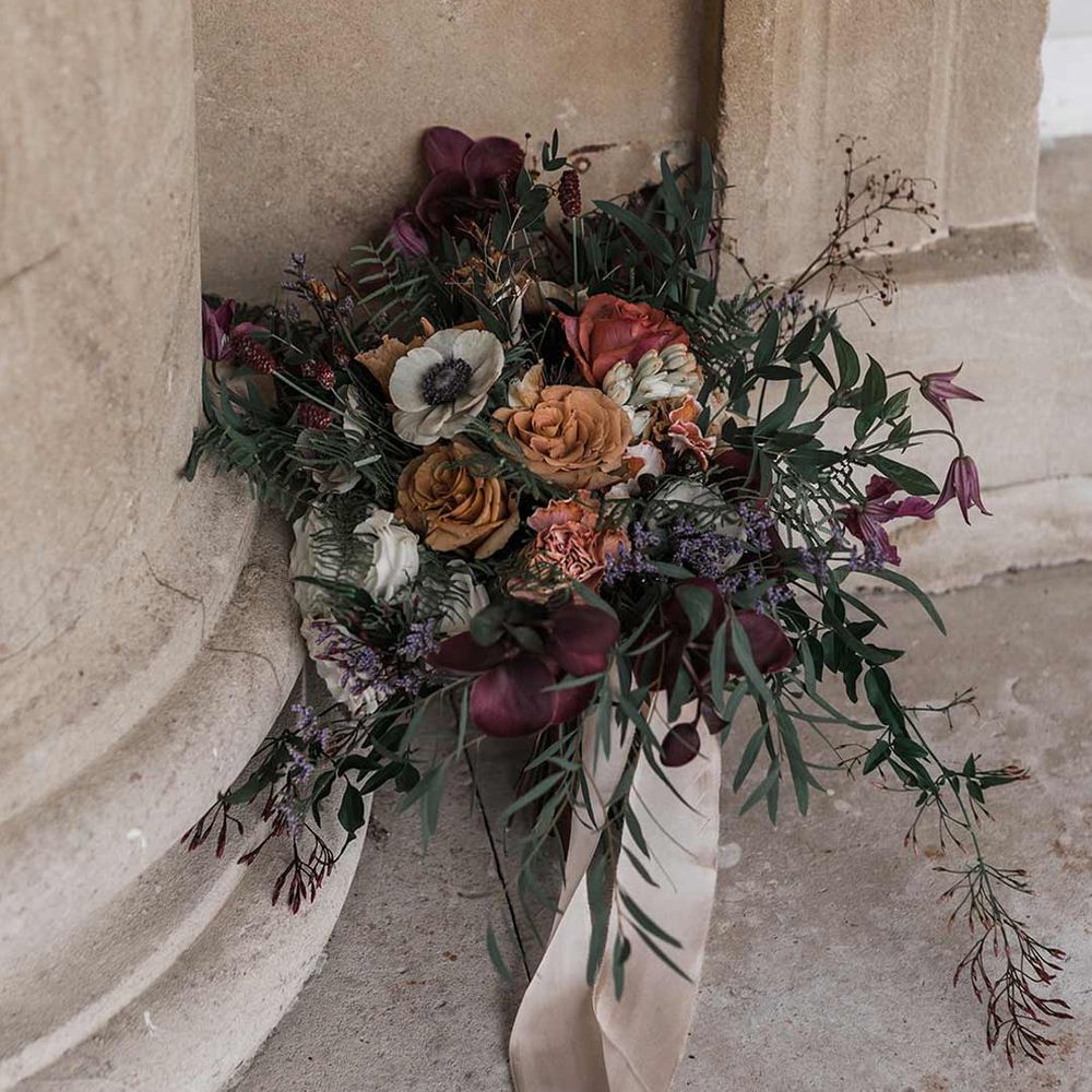Dried wildflower wedding bouquet with off white neutral ribbon tied around at Buxted Park