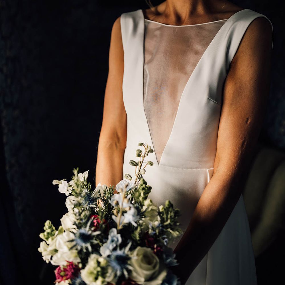 Bride holding a colourful bouquet for a spring wedding in an Andrea Hawkes wedding dress 