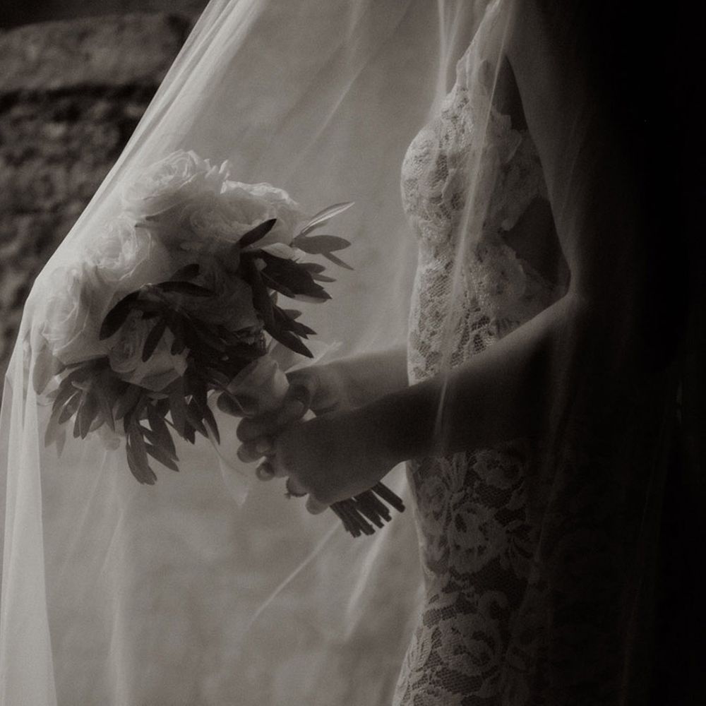 Bride holding a round white rose wedding bouquet 