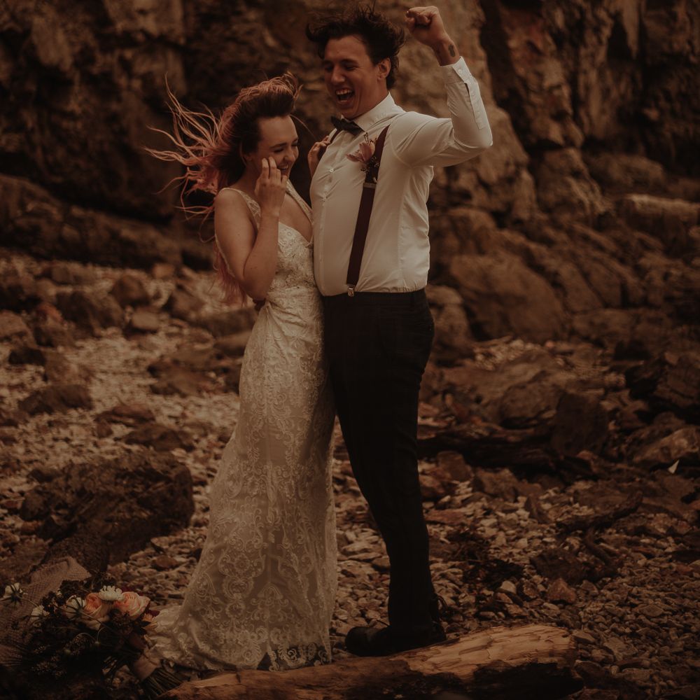 Bride in lace wedding dress and groom in braces at elopement wedding