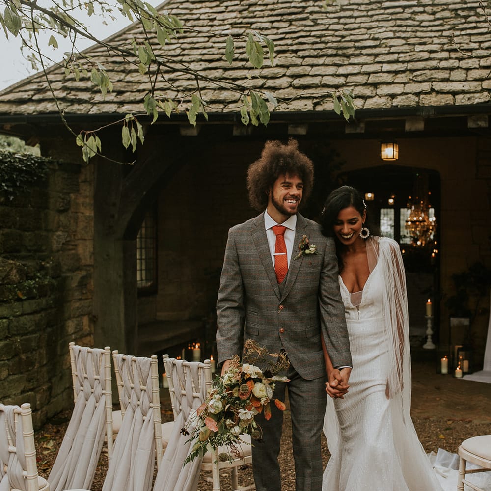 Bride and groom holding hands at their outdoor wedding ceremony 