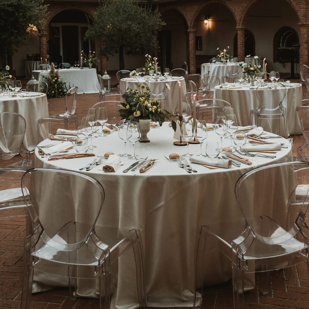Tablescape with ghost chairs, blue and white flower centrepiece and candles 