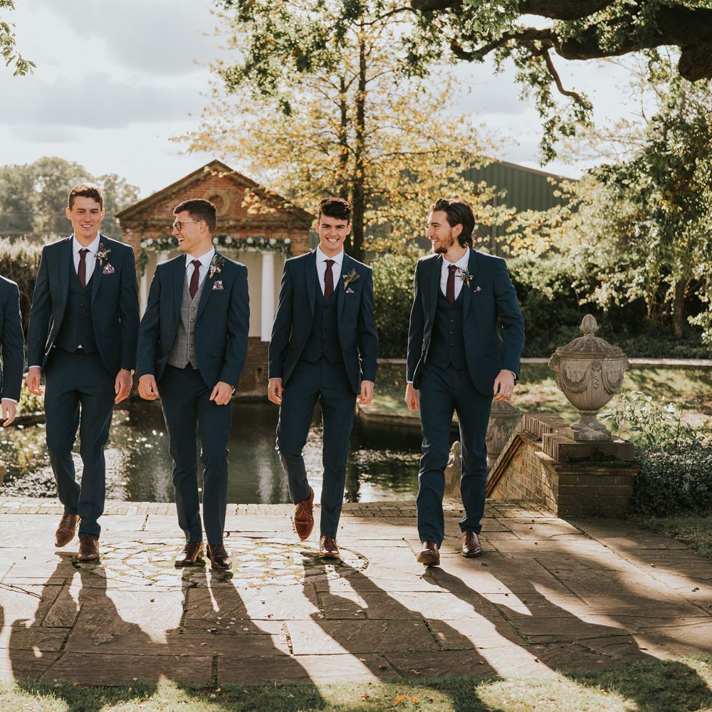 Grooms walks with his groomsmen outdoors