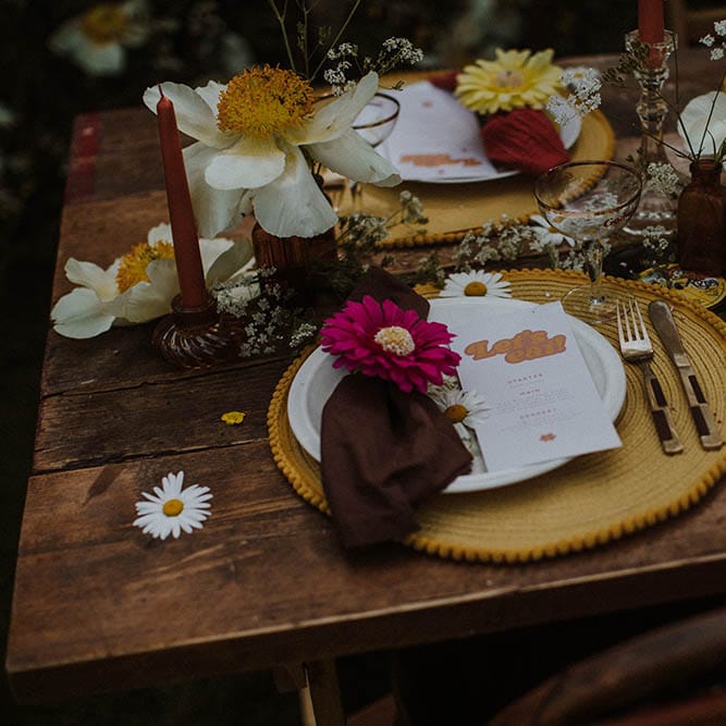 Place setting with round yellow placemats, gold cutlery and retro on the day stationery 