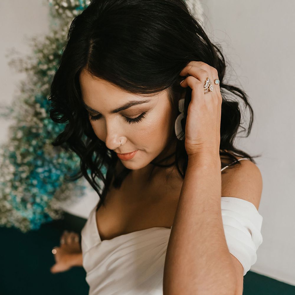 Bride with bronze shimmering eye shadow and peach lipstick in a cold shoulder wedding dress 