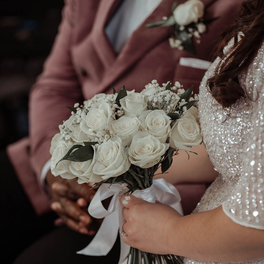 Bride holds white classic floral bouquet