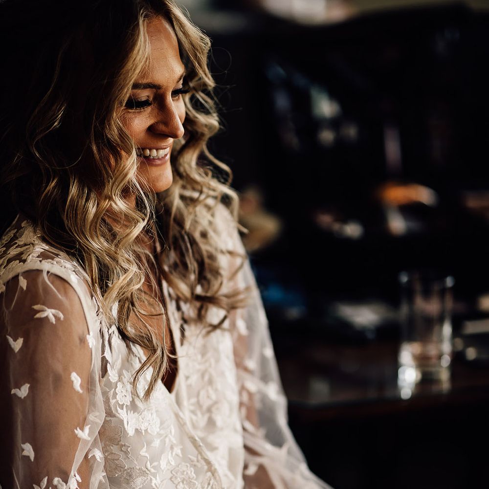 Bride gets ready for her wedding day wearing sheer lace robe with French tip wedding nails 