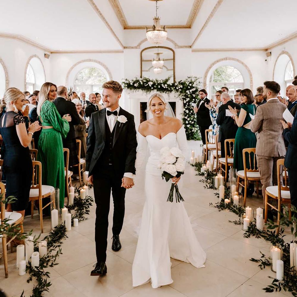 Elegant black tie wedding at Northbrook Park with bride in a fitted off the shoulder wedding dress