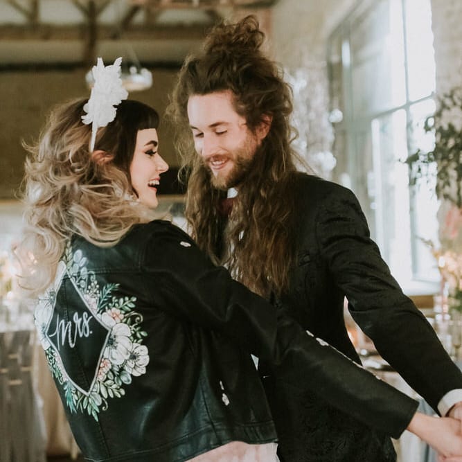 Bride and groom dancing at their Hooton Pagnell reception with the bride wearing a hand painted leather jacket 