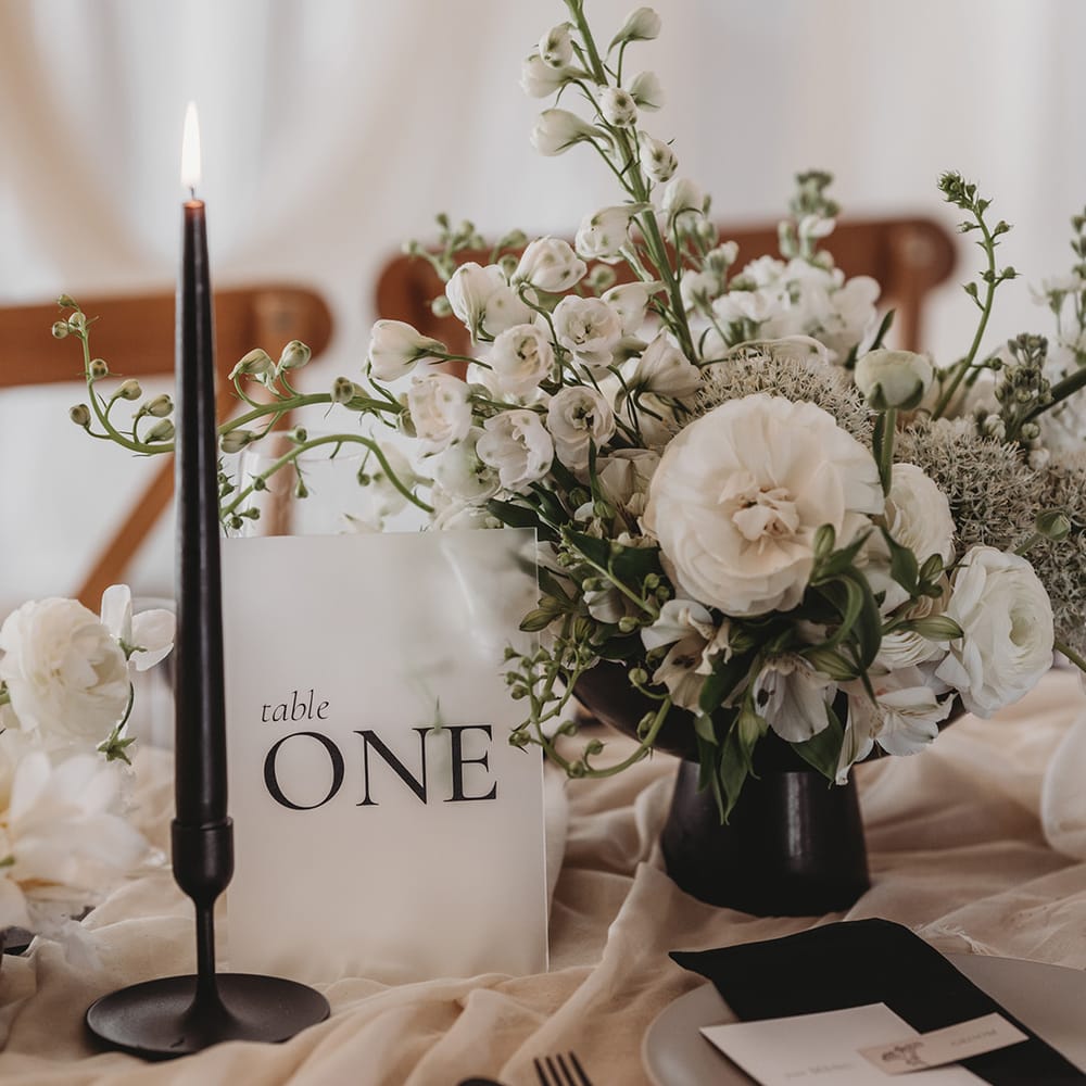 Frosted acrylic wedding sign with black taper candles and white wedding flowers for table decoration 