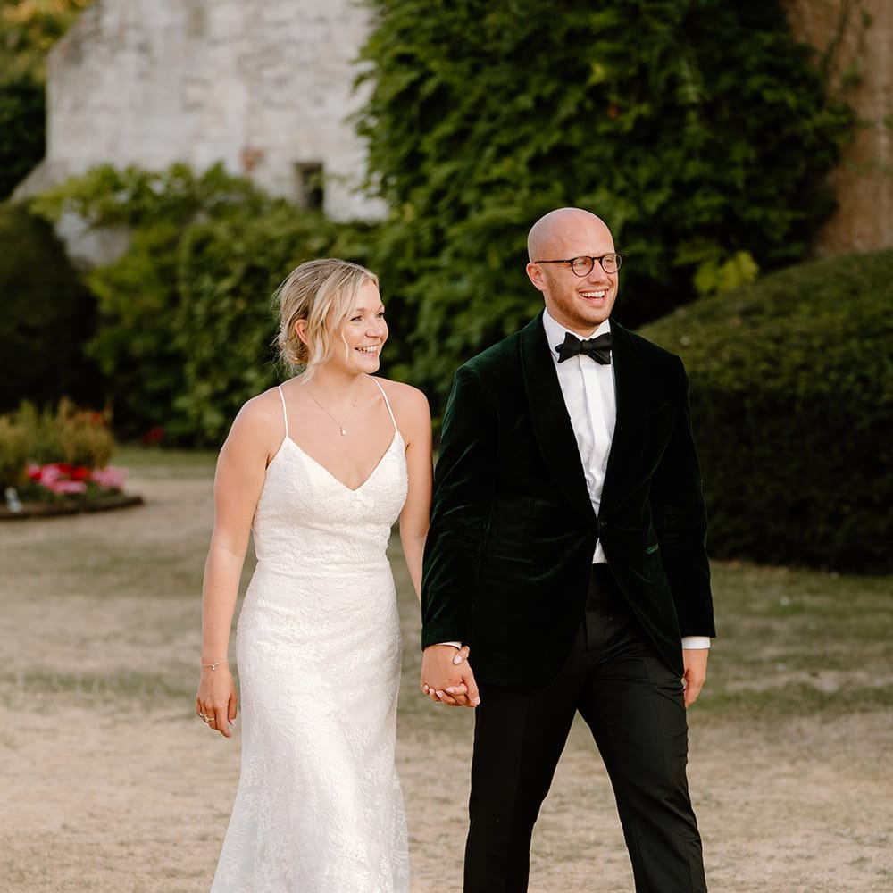 Bride & groom walk outdoors at Bisham Abbey on their wedding day 