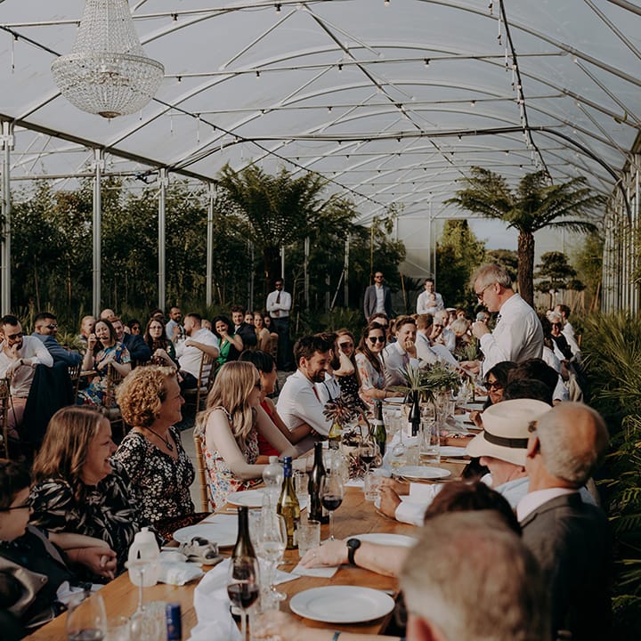 Seated guests in a greenhouse watching the speeches