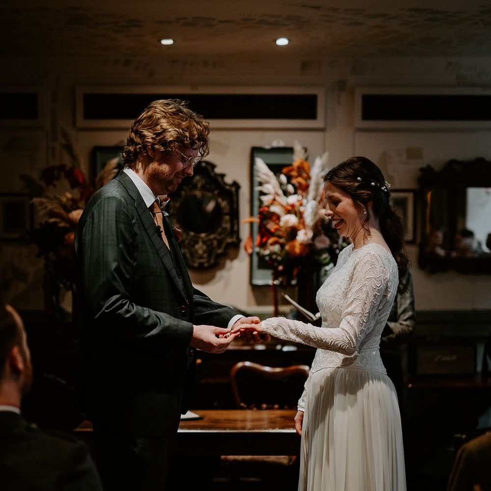 Bride and groom exchanging rings at autumnal London intimate wedding ceremony 