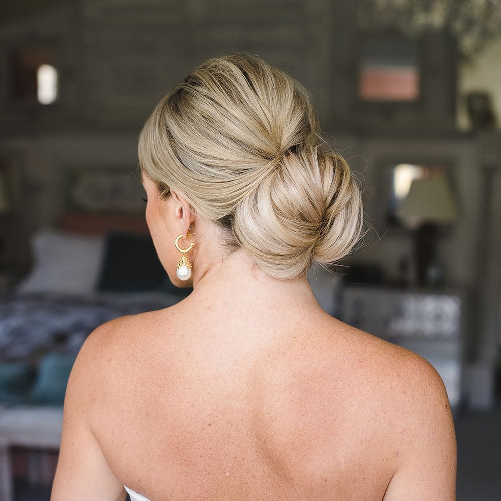 Bride wearing her blonde hair in a traditional updo hairstyle 
