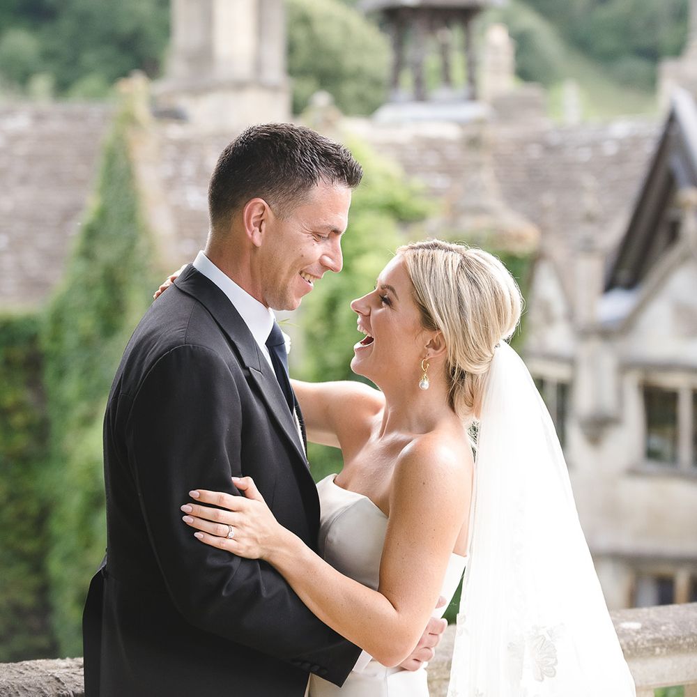 The bride and groom smile brightly together for their couple portraits at The Manor House, Castle Combe 