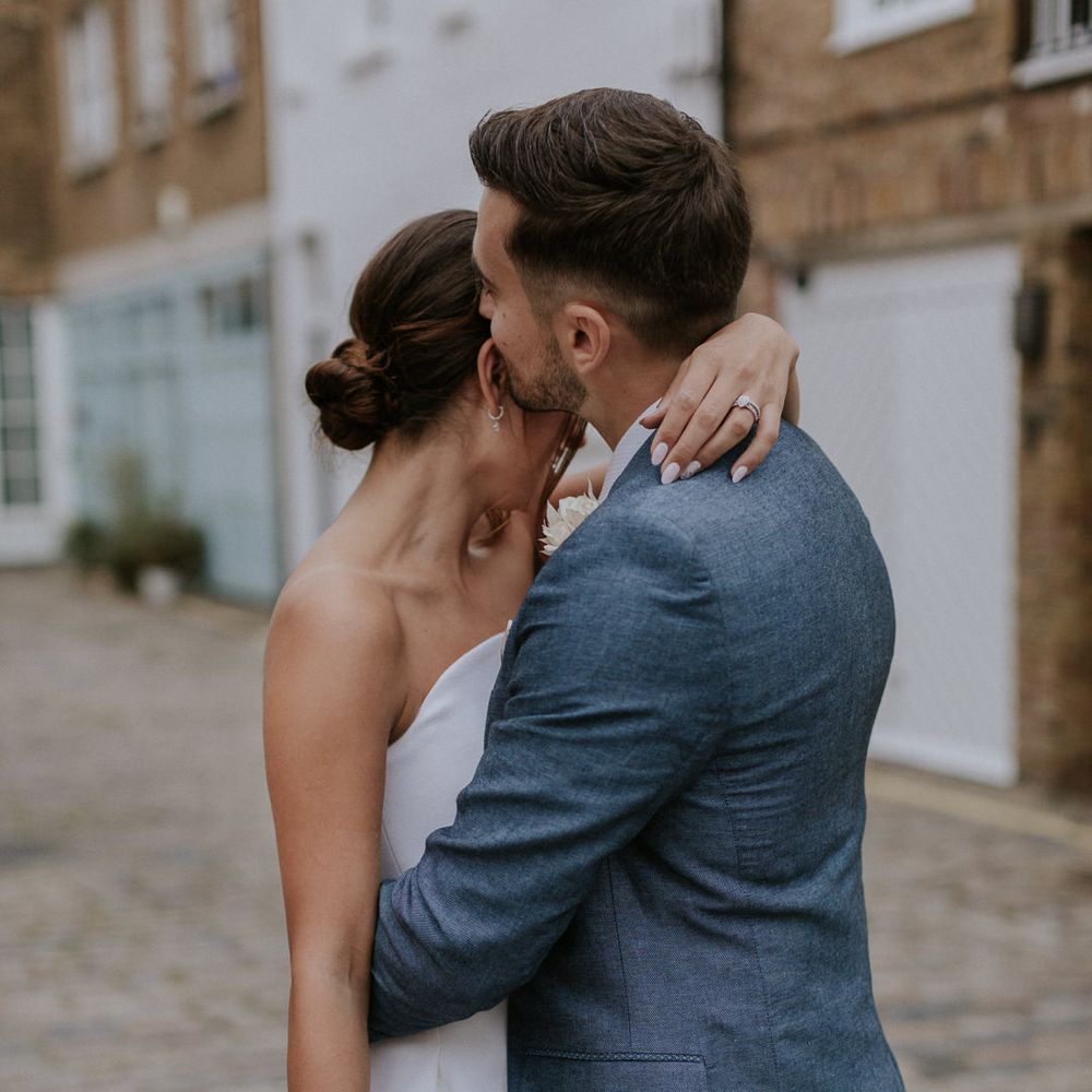 Bride and groom embracing in London streets 
