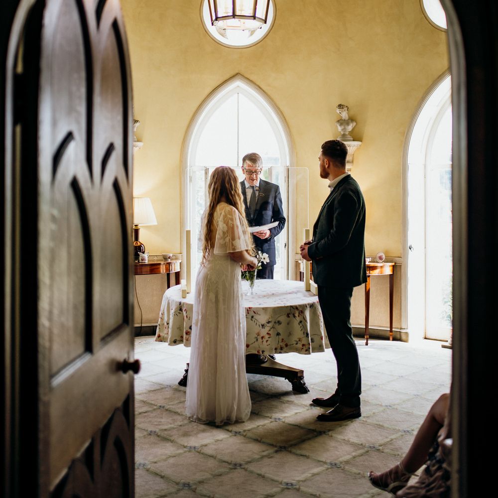 Bride & groom through arch doorway 