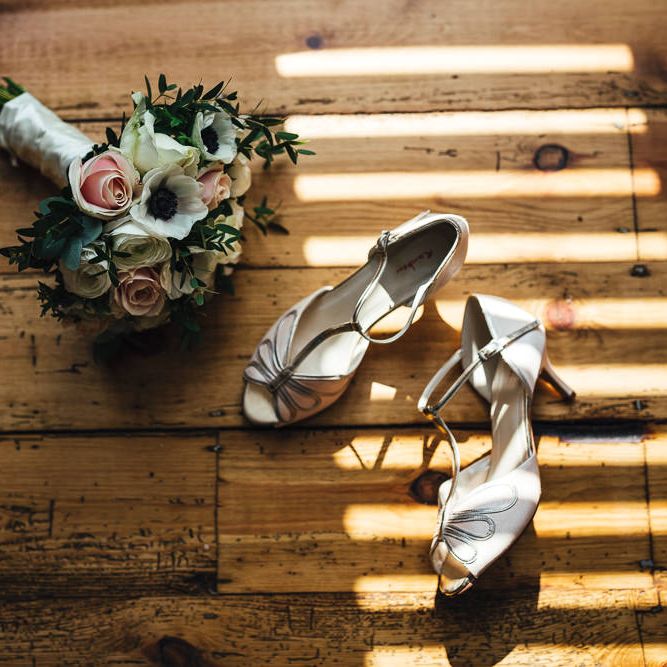 Bridal shoes from the Rainbow Club next to floral bouquet
