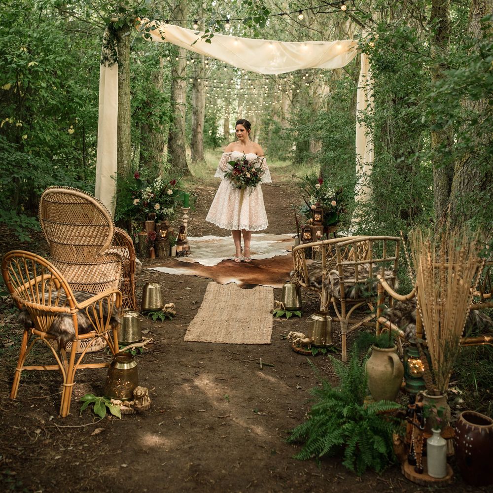 Bride stands under trees with lights hanging down