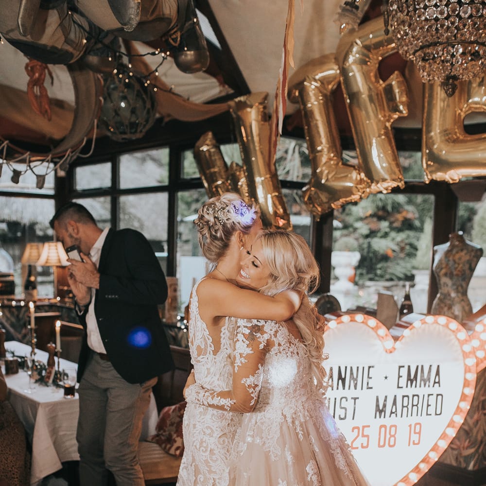 Two brides have a first dance at their wedding reception.
