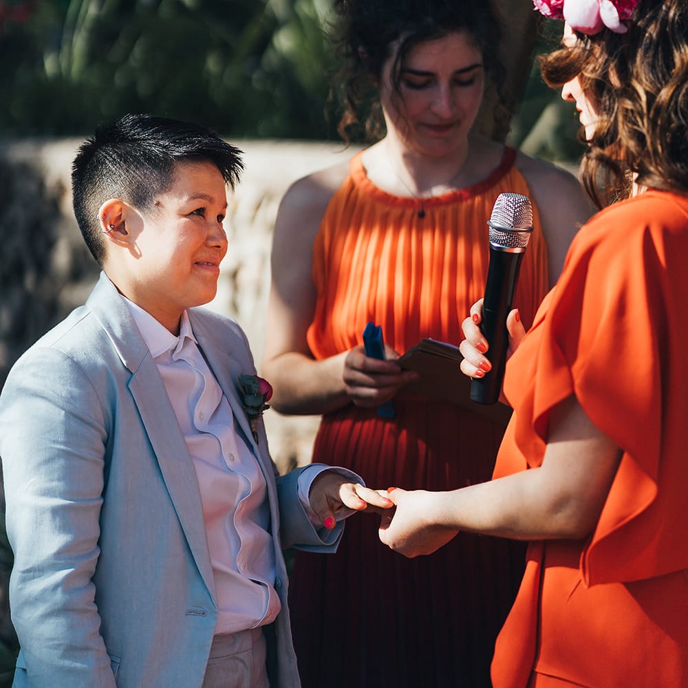 Brides exchange rings during vows 