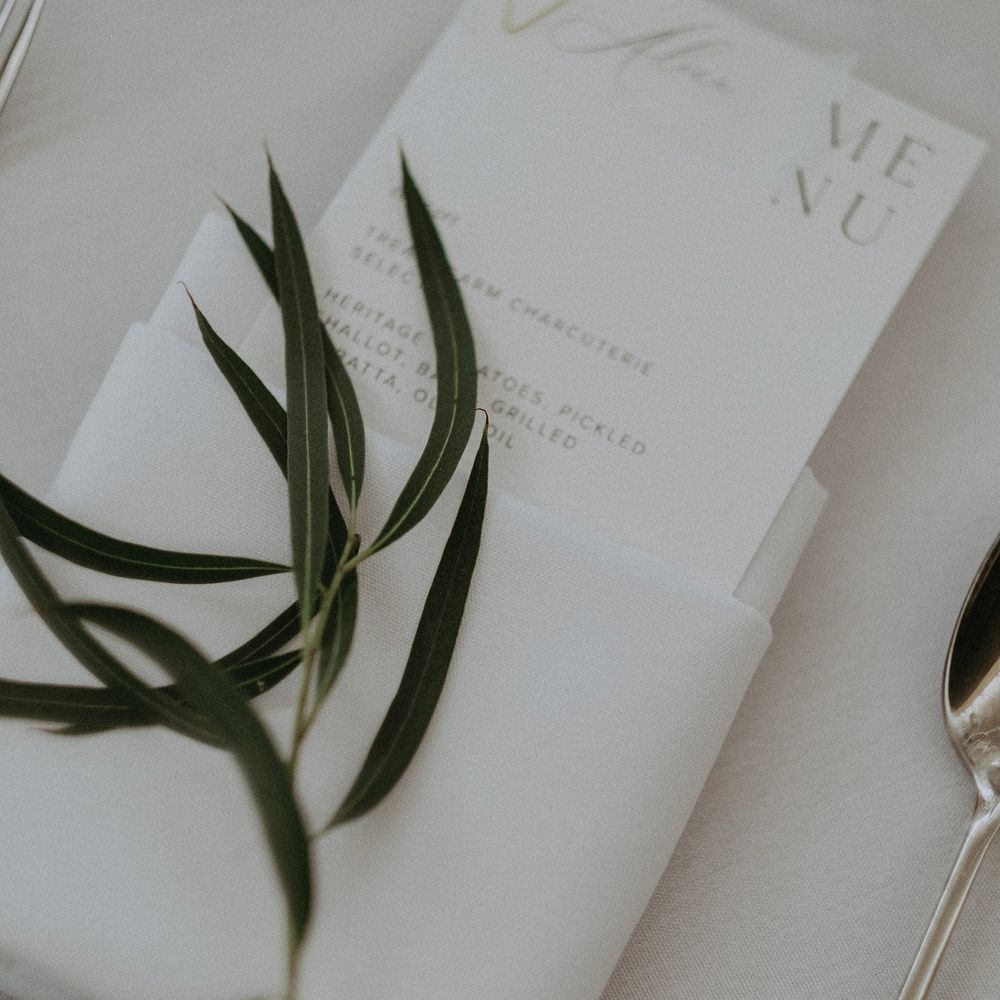 White stationery for reception complete with rosemary decoration