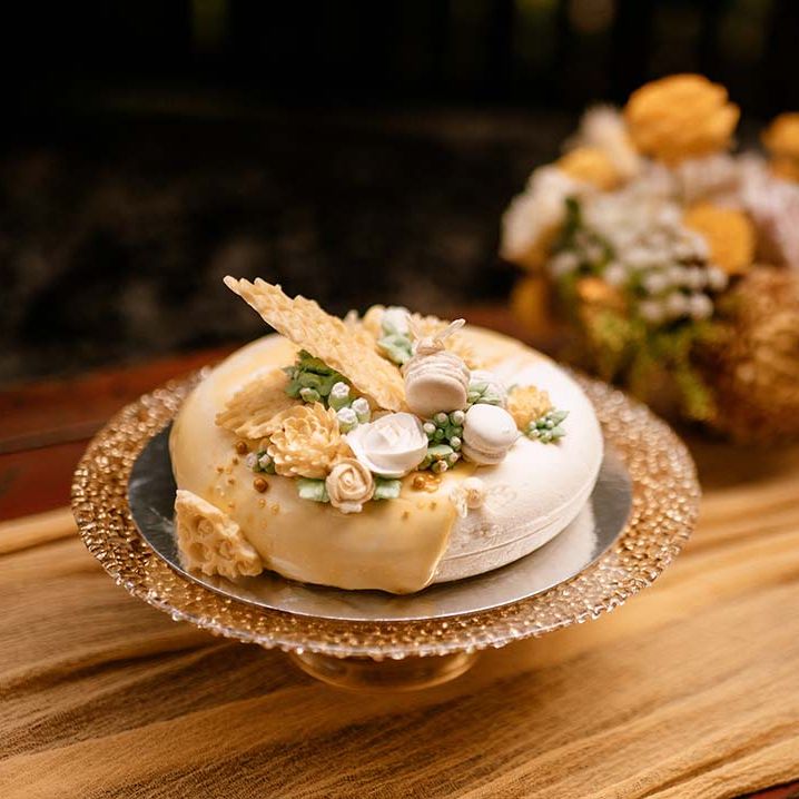 Wedding cake on a gold cake stand with with honeycomb and macaroon decor 