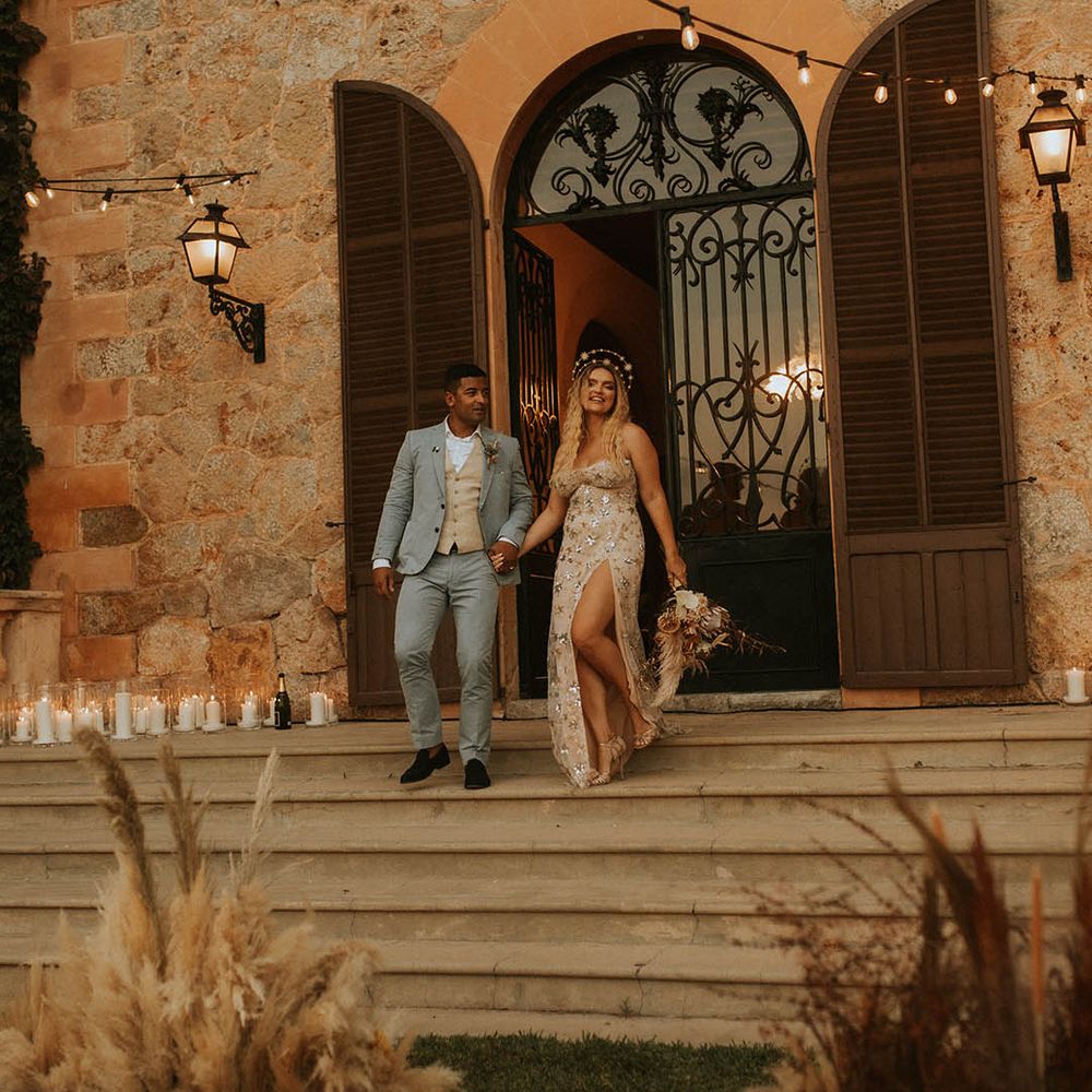 Bride & groom stand on staircase outdoors on their wedding day