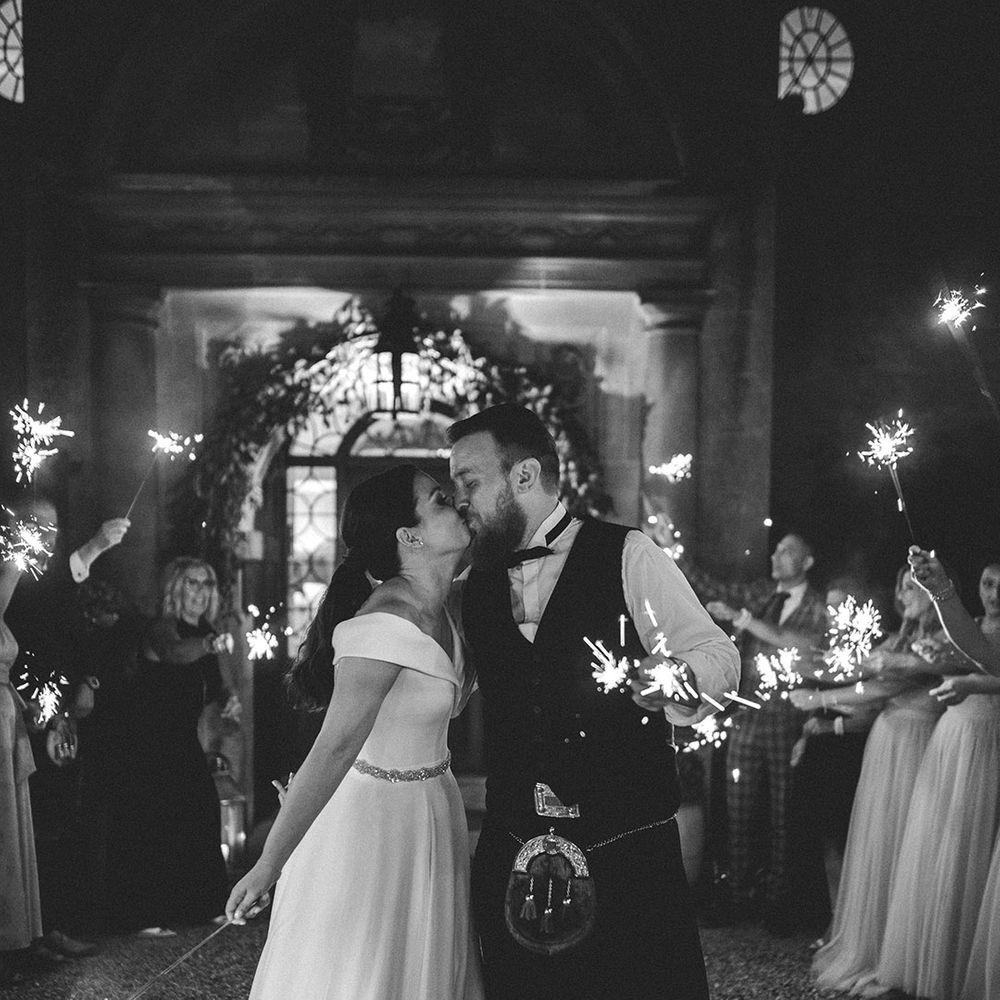 Sparkler moment at Foxhill Manor with bride in a Bardot wedding dress and groom in a tartan kilt 