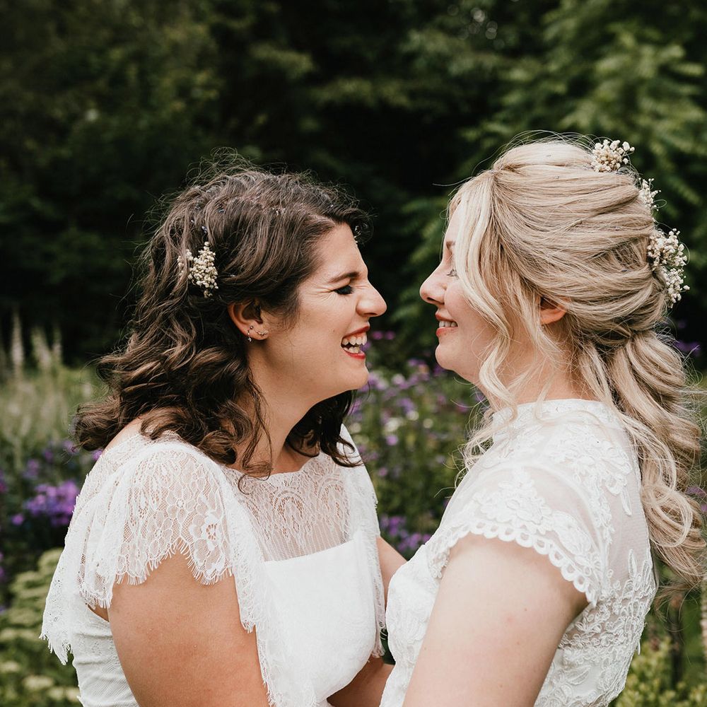 Brides laugh and smile at one another 
