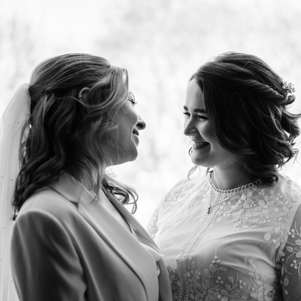 Two brides look at one another lovingly in black and white image
