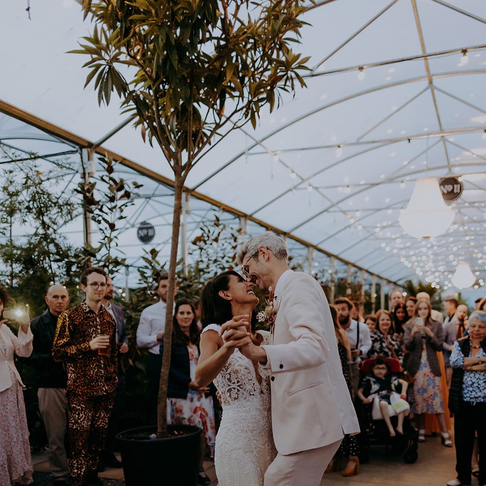 Bride and Groom share intimate dance with fairy lights in the background