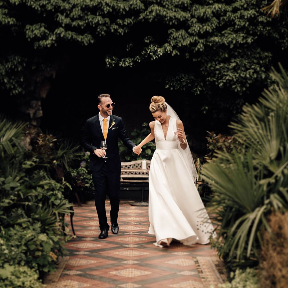 Gift list wedding at Hampton Court House in Surrey with bride in plunging Sheila Harding wedding dress with groom in navy suit 