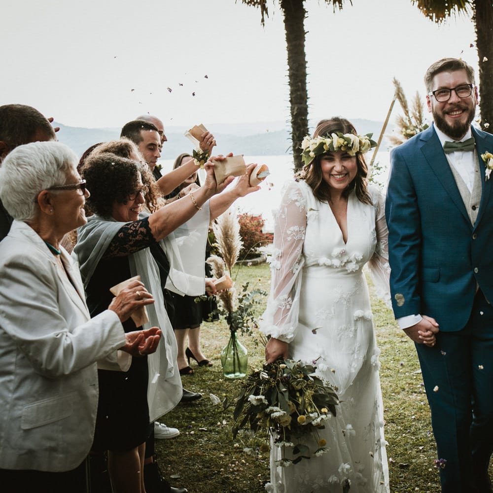 Happy bride and groom walking up the aisle as husband and wife with confetti being thrown over them.