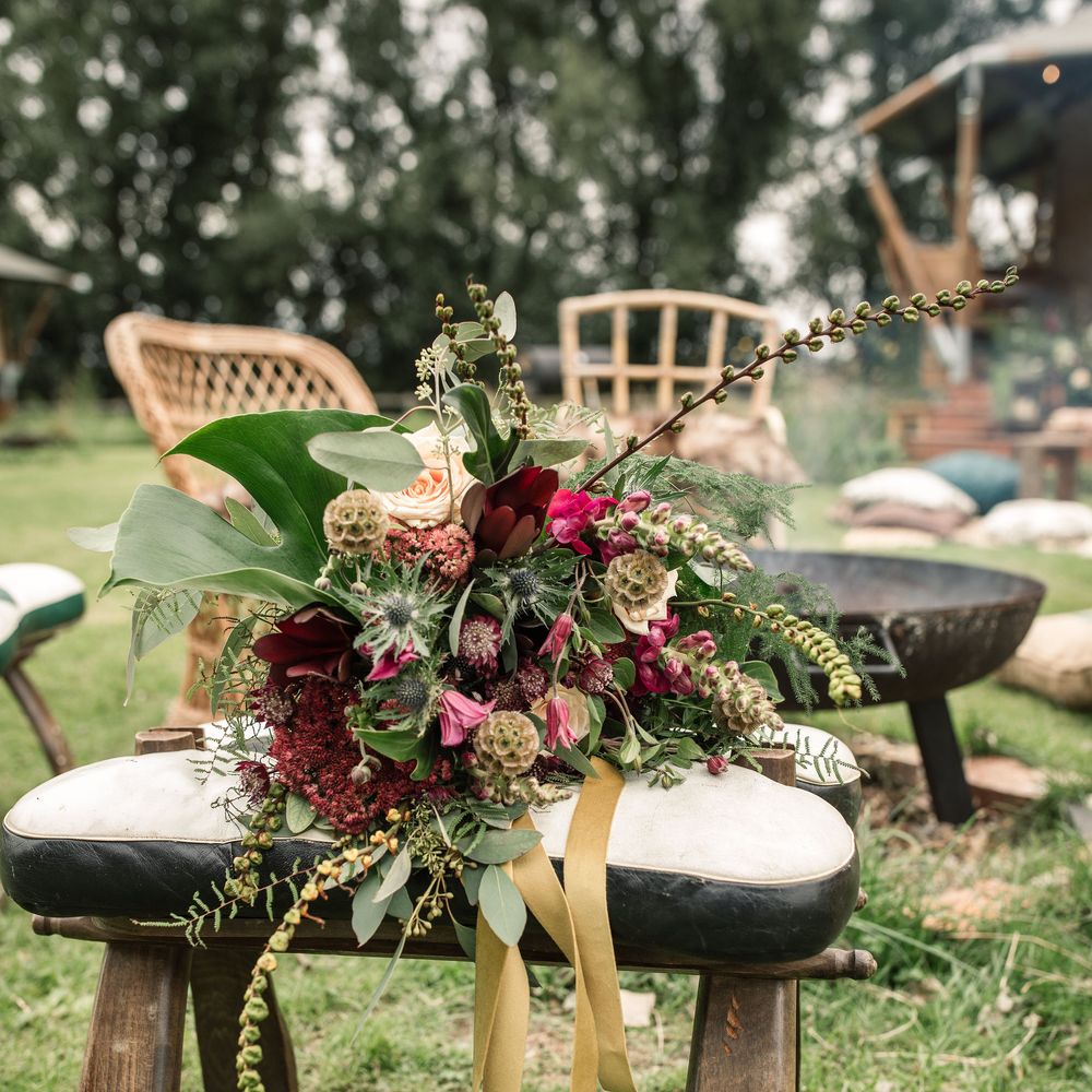 Floral bouquet featuring red blooms and green foliage on wooden chair